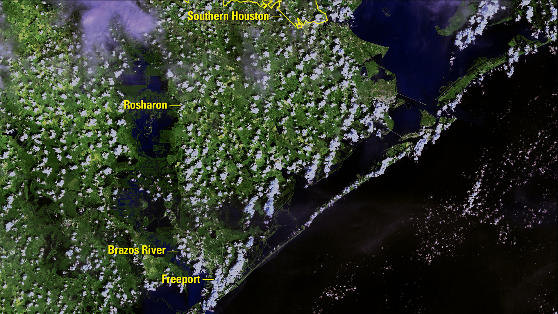 USGS Landsat 7 view from September 5, 2017, with broad dark floodwater along the Brazos near Rosharon and toward Freeport; clouds obscure parts of the land.